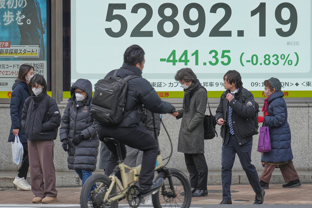 People stand in front of an electronic stock board showing Japan's Nikkei index at a securities firm Wednesday, Jan. 28, 2026, in Tokyo. (AP Photo/Eugene Hoshiko)