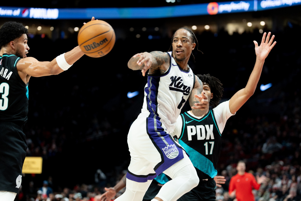 Sacramento Kings guard Demar Derozan, center, passes the ball against the Portland Trail Blazers during the first half of an NBA basketball game Thursday Dec. 18, 2025, in Portland, Ore. (AP Photo/Howard Lao)