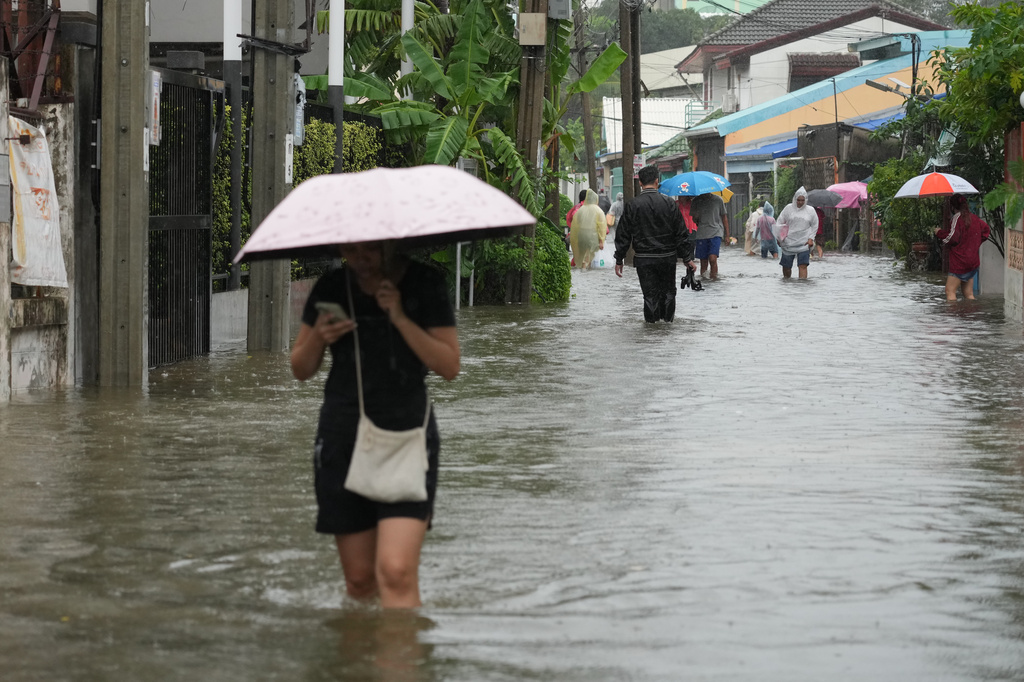 People wade through floodwaters after heavy rain in Bangkok, Thailand, Saturday, Sept. 26, 2026. (AP Photo/Sakchai Lalit)
