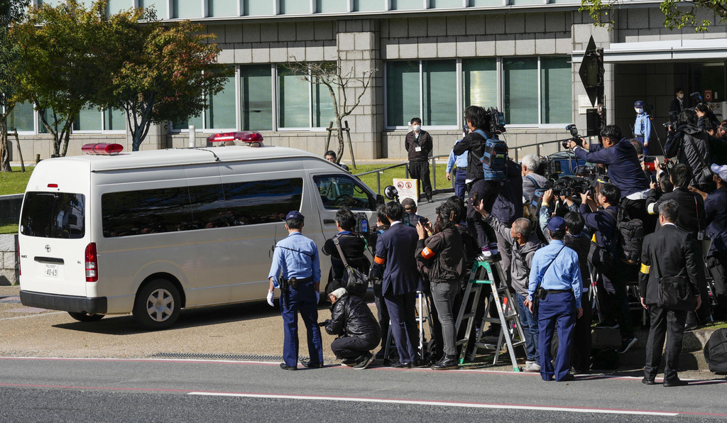 Journalists crowd as a vehicle which is belived to be carrying Tetsuya Yamagami, the accused killer of former Japanese Prime Minister Shinzo Abe, arrives for a trial at the Nara District Court in Nara, western Japan Tuesday, Oct. 28, 2025. (Shohei Miyano/Kyodo News via AP)