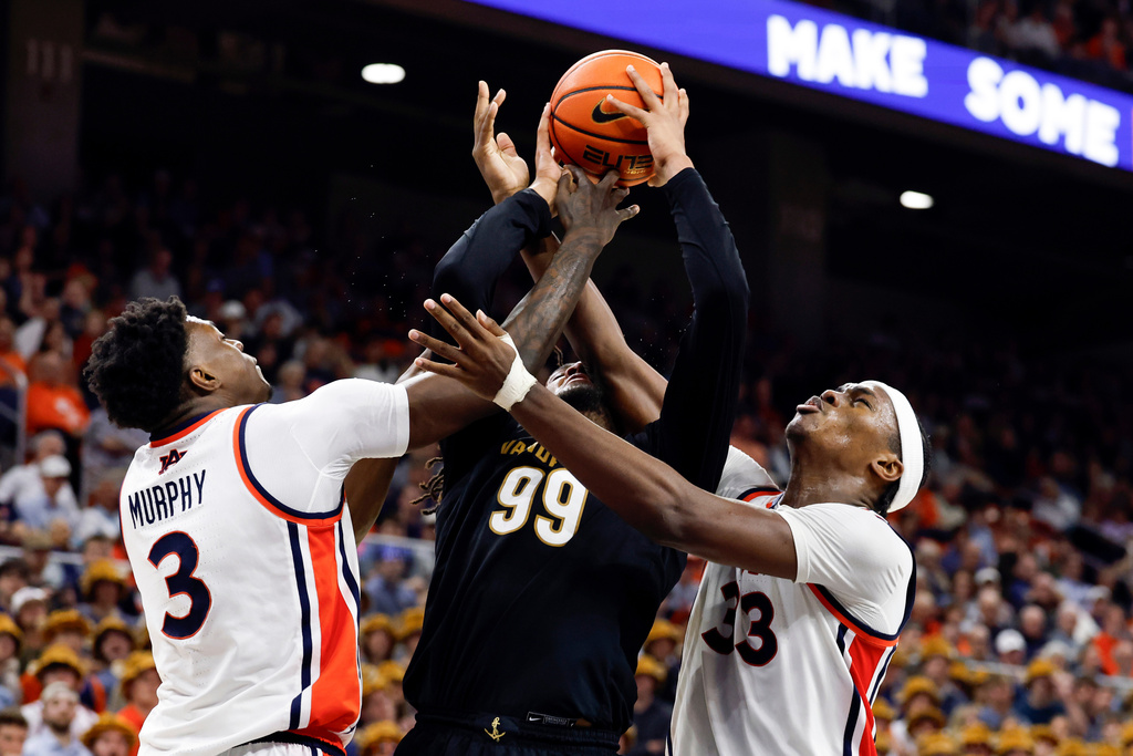 Vanderbilt forward Devin McGlockton (99) is fouled by Auburn forward Sebastian Williams-Adams (33) as he goes up for a shot with forward Keshawn Murphy (3) defending during the first half of an NCAA college basketball game Tuesday, Feb. 10, 2026, in Auburn, Ala. (AP Photo/Butch Dill)