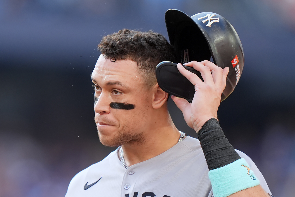 New York Yankees outfielder Aaron Judge (99) walks back to the dugout at the end of the top of the first inning in Game 1 of baseball's American League Division Series against the Toronto Blue Jays, Saturday, Oct. 4, 2025, in Toronto. (Nathan Denette/The Canadian Press via AP)