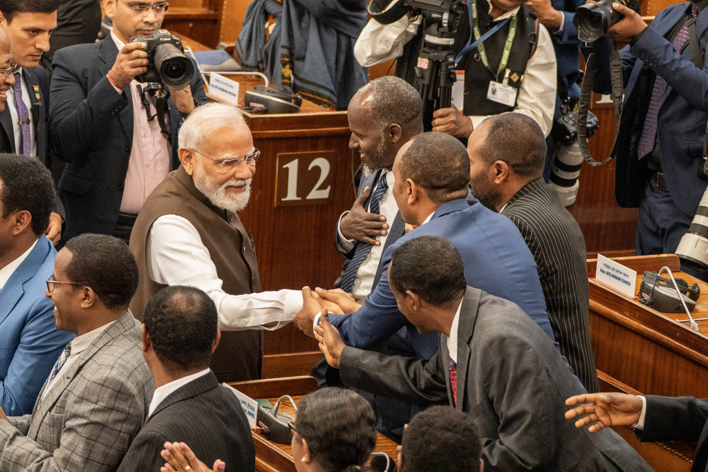 Indian Prime Minister Narendra Modi, center left, shakes hands with Ethiopian lawmakers inside parliament in Addis Ababa, Ethiopia, Wednesday, Dec. 17, 2025. (AP Photo/ Amanuel Sileshi)