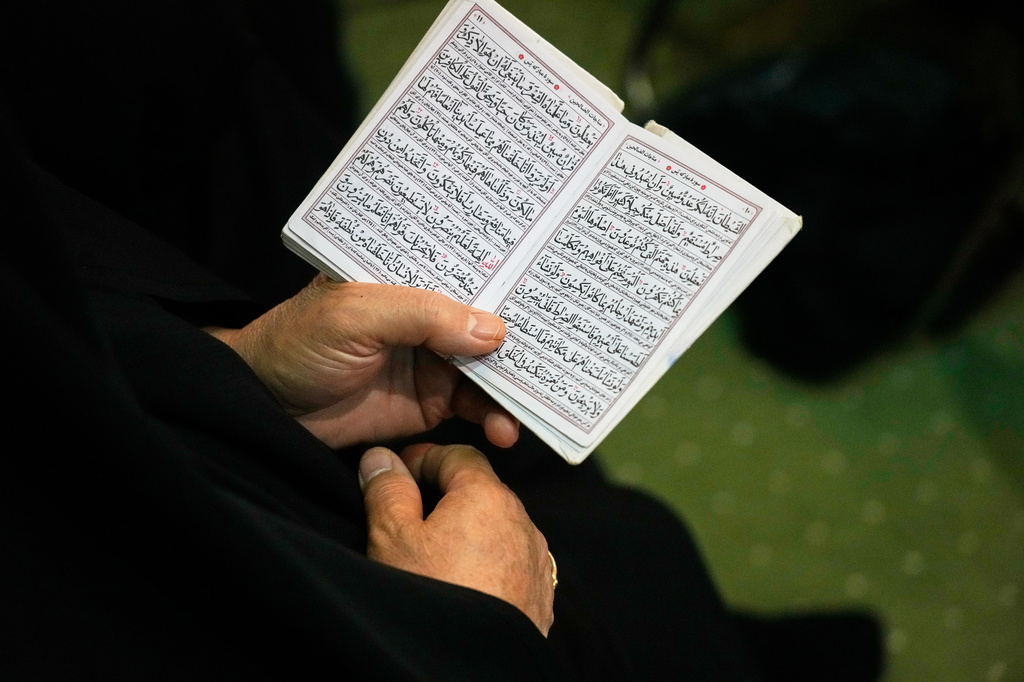 A woman reads passages from Islam's holy book, the Quran, during a ceremony honoring the armed forces and those killed in the war with Israel and the U.S. at the Imam Khomeini Grand Mosque in Tehran, Iran, Sunday, May 24, 2026. (AP Photo/Vahid Salemi)