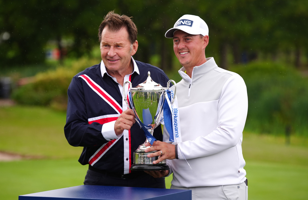 Joe Dean of England, right, receives the trophy from Nick Faldo on day four of the British Masters at The Belfry Hotel & Resort, Sutton Coldfield, England, Sunday Aug. 30, 2026. (Bradley Collyer/PA via AP)