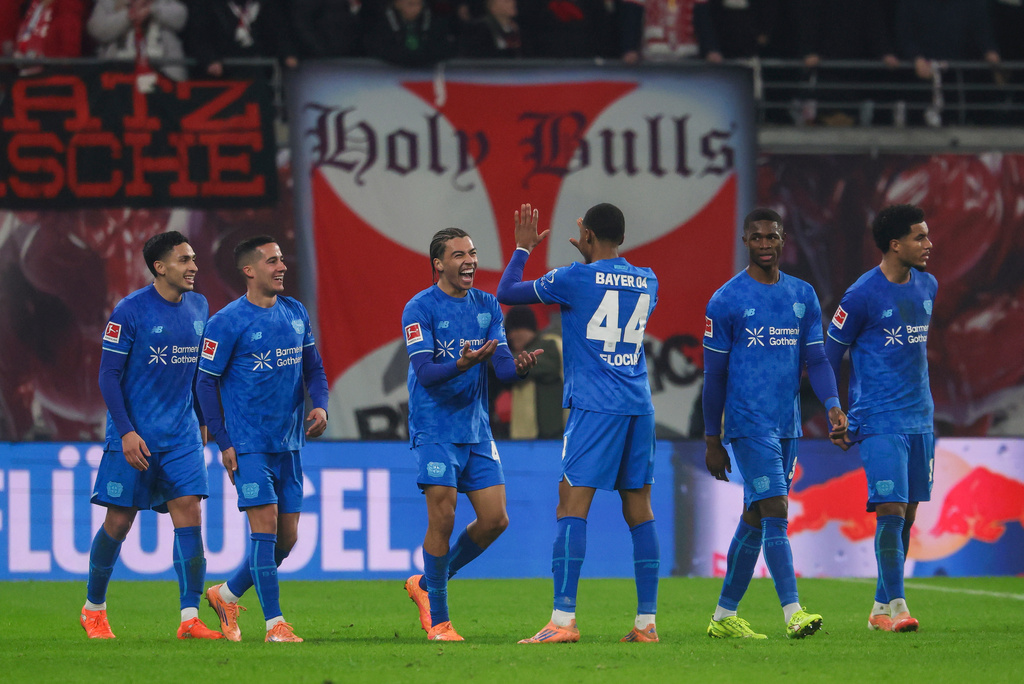 Montrell Culbreath of Bayer Leverkusen, third from left, celebrates with teammates after scoring to make it 1:3 during the Bundesliga soccer match between RB Leipzig and Bayer Leverkusen, in Leipzig, Germany, Saturday Dec. 20, 2025. (Jan Woitas/dpa via AP)