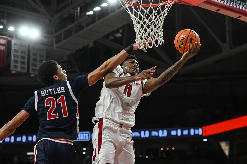Arkansas guard Karter Knox (11) drives past Jackson State forward Kobe Butler (21) during the first half of an NCAA college basketball game Friday, Nov. 21, 2025, in Fayetteville, Ark. (AP Photo/Michael Woods)