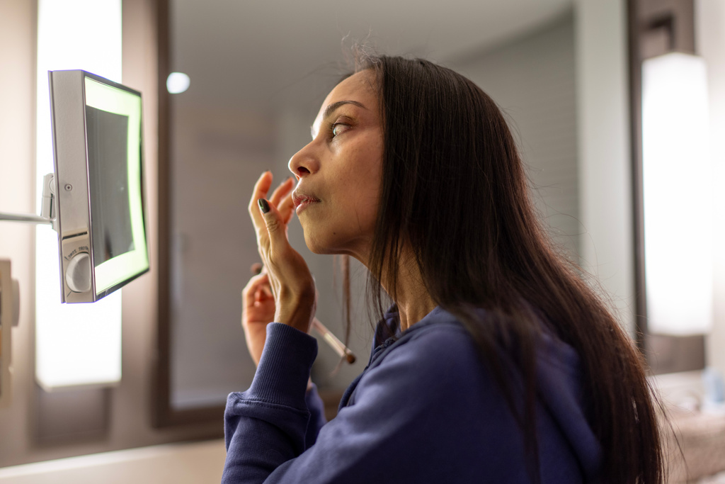 Ruth Wilson, who balances her lupus illness with volunteering to help other patients, puts on makeup as she gets ready for the Walk with Us to Cure Lupus fundraising event, Saturday, Oct. 18, 2025, in New York. (AP Photo/David Goldman)