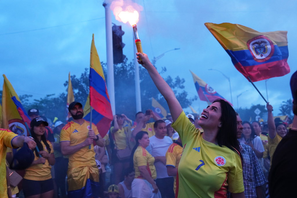A supporter of presidential candidate Abelardo de la Espriella of the opposition Defenders of the Motherland movement light a flare at a celebration rally after polls closed in the runoff election in Barranquilla, Colombia, Sunday, June 21, 2026. (AP Photo/Rodrigo Abd)