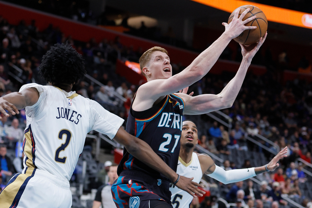 Detroit Pistons guard Kevin Huerter (27) goes to the basket between New Orleans Pelicans forward Herbert Jones (2) and guard Dejounte Murray (5) during the first half of an NBA basketball game Thursday, March 26, 2026, in Detroit. (AP Photo/Duane Burleson)