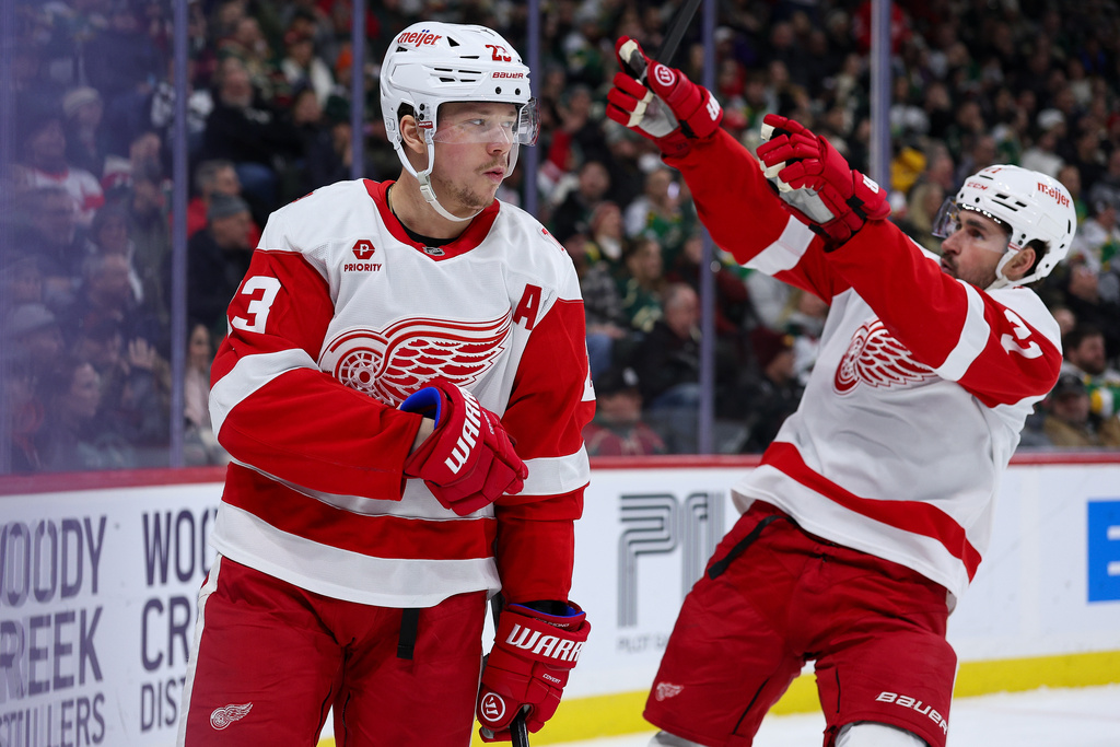 Detroit Red Wings left wing Lucas Raymond (23) celebrates after his goal as center Dylan Larkin, right, points to fans during the second period of an NHL hockey game against the Minnesota Wild, Thursday, Jan. 22, 2026, in St. Paul, Minn. (AP Photo/Matt Krohn)