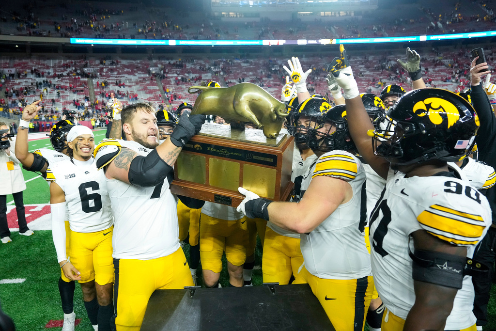 Iowa celebrates with The Heartland Trophy after beating Wisconsin in an NCAA college football game Saturday, Oct. 11, 2025, in Madison, Wis. (AP Photo/Andy Manis)