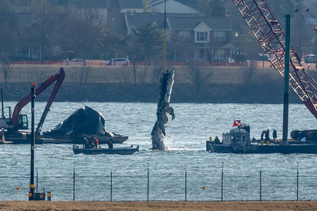 FILE - A piece of wreckage is lifted from the water onto a salvage vessel near the site in the Potomac River of a mid-air collision between an American Airlines jet and a Black Hawk helicopter, at Ronald Reagan Washington National Airport, Feb. 4, 2025, in Arlington, Va. (AP Photo/Ben Curtis, File)