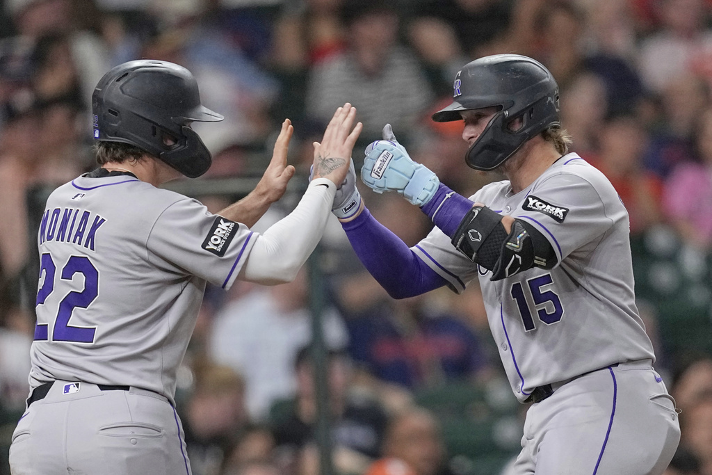Colorado Rockies' Hunter Goodman (15) celebrates with Mickey Moniak (22) after both scored on Goodman's home run against the Houston Astros during the third inning of a baseball game Tuesday, Aug. 26, 2025, in Houston. (AP Photo/David J. Phillip)