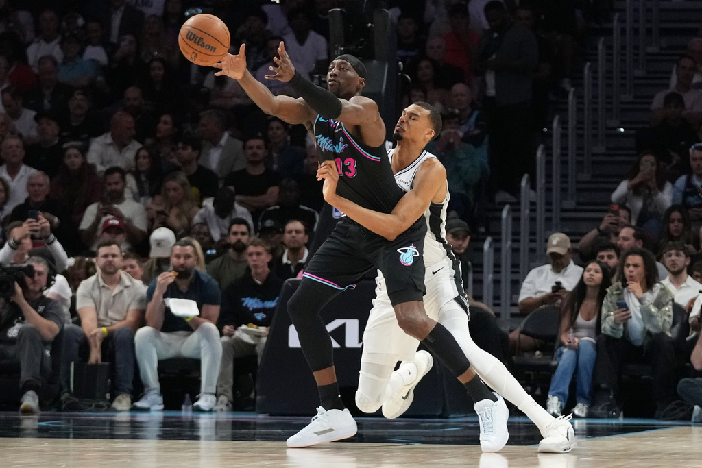 Miami Heat center Bam Adebayo (13) is fouled by San Antonio Spurs forward Victor Wembanyama, right, during the first half of an NBA basketball game, Monday, March 23, 2026, in Miami. (AP Photo/Lynne Sladky)
