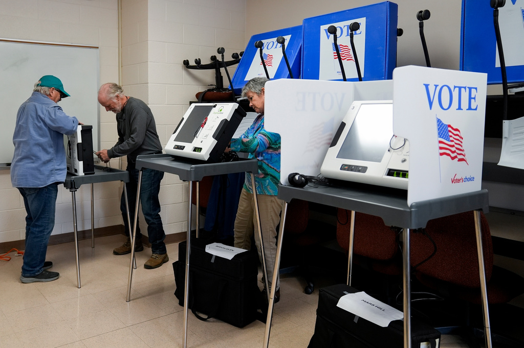 FILE - Poll workers set up ballot-marking machines at an early in-person voting site at Asheville-Buncombe Technical Community College, Oct. 16, 2024, in Marshall, N.C. (AP Photo/Stephanie Scarbrough, File)