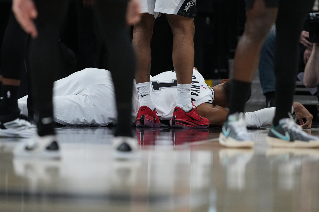 San Antonio Spurs forward Victor Wembanyama (1) lies on the court after a hard fall during the first half in Game 2 of a first-round NBA playoffs basketball series against the Portland Trail Blazers in San Antonio, Tuesday, April 21, 2026. (AP Photo/Eric Gay)