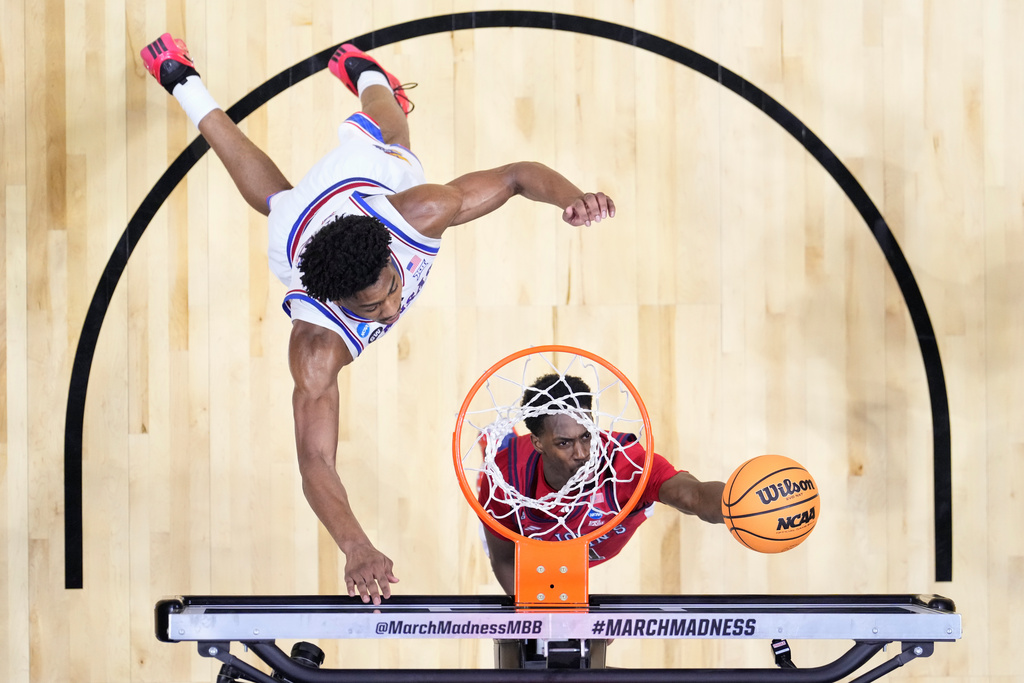 St. John's guard Ian Jackson (11) shoots around Kansas forward Bryson Tiller (15) during a game in the second round of the NCAA college basketball tournament Sunday, March 22, 2026, in San Diego. (AP Photo/Mark J. Terrill)