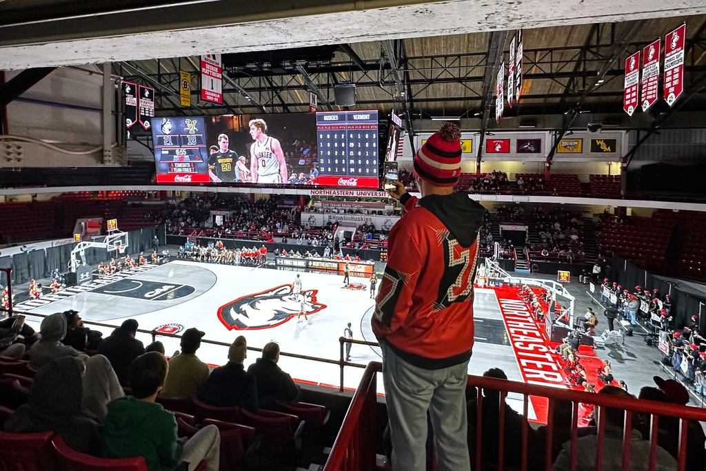 A fan watches a basketball game between Northeastern University and Vermont at Northeastern's Matthews Arena, Nov. 24, 2025, in Boston. (AP Photo/Jimmy Golen)