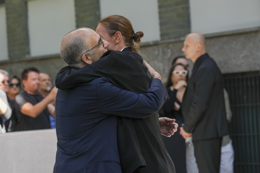 Italian film director Giuseppe Tornatore, left, is hugged as he arrives to pay his respects to fashion designer Giorgio Armani, lying in state at the Armani/Teatro in Milan, northern Italy, Saturday, Sept. 6, 2025. (AP Photo/Antonio Calanni)
