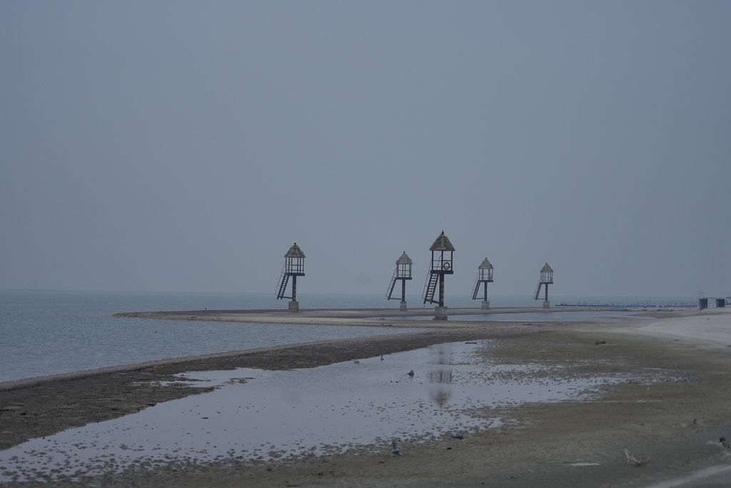 Watchtowers stand at an empty beach at the semi-abandoned "Life in Venice" housing complex in Qidong, on China's east coast, Feb. 5, 2026. (AP Photo/Dake Kang)