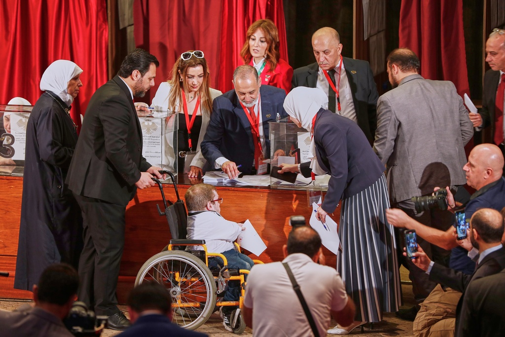 Syrian electoral college members line up to cast their ballots in a parliamentary election at a polling station in Damascus, Syria, Sunday, Oct. 5, 2025. (AP Photo/Omar Sanadiki)