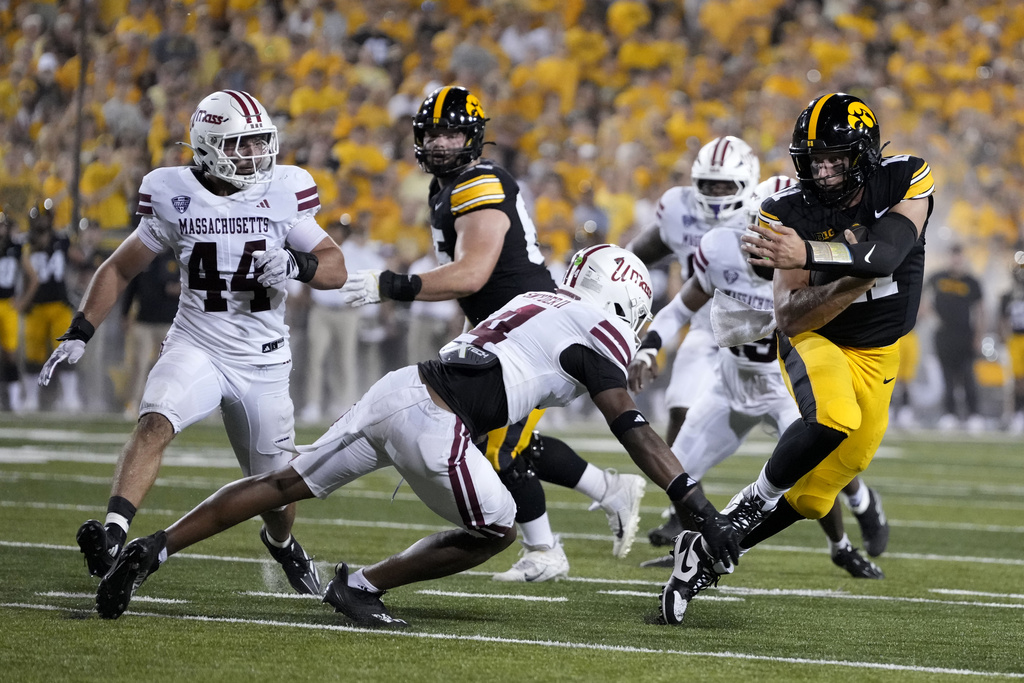 Iowa quarterback Mark Gronowski runs from Massachusetts safety DD Snyder (4) during a touchdown run in the first half of an NCAA college football game, Saturday, Sept. 13, 2025, in Iowa City, Iowa. (AP Photo/Charlie Neibergall)