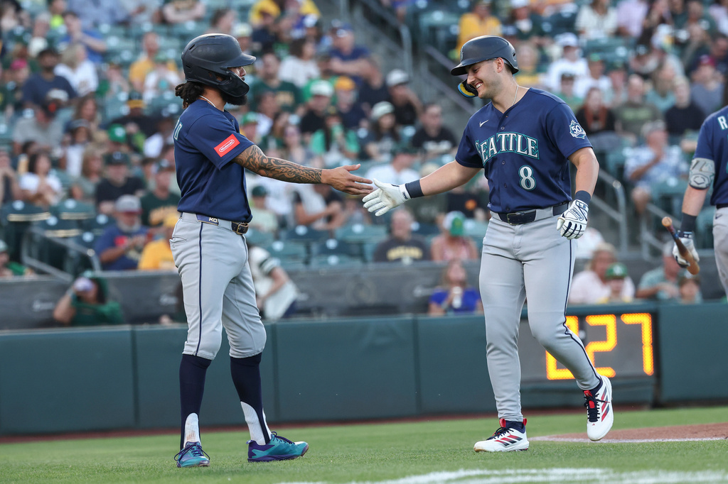 Seattle Mariners' Dominic Canzone (8) high-fives J.P. Crawford, left, after hitting a two-run home run during the first inning of a baseball game against the Athletics Saturday, Sept. 12, 2026, in West Sacramento, Calif. (AP Photo/Sara Nevis)