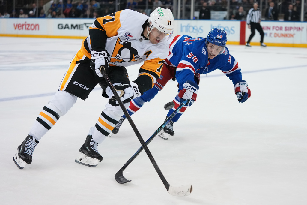 Pittsburgh Penguins' Evgeni Malkin (71) drives past New York Rangers' Gabe Perreault (94) during the overtime period of an NHL hockey game Saturday, Feb. 28, 2026, in New York. (AP Photo/Frank Franklin II)