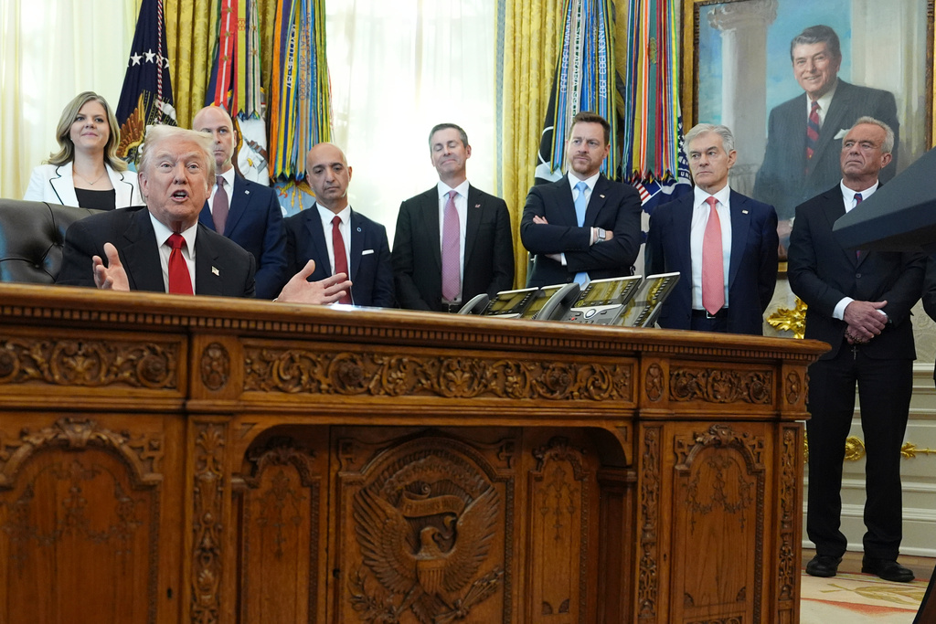 President Donald Trump speaks as Heidi Overton, deputy director of the White House Domestic Policy Council, from left, David Moore, president of Novo Nordisk Inc., Novo Nordisk President and CEO Mike Doustdar, Eli Lilly CEO David Ricks, Chris Klomp, director of the Centers for Medicare and Medicaid Services, Mehmet Oz, administrator of the Centers for Medicare & Medicaid Services, and Health and Human Services Secretary Robert F. Kennedy Jr. listen during an event about drug prices, Thursday, Nov. 6, 2025, in the Oval Office of the White House in Washington. (AP Photo/Evan Vucci)