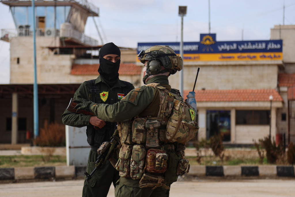 Internal security officers with the Kurdish-led Syrian Democratic Forces (SDF) stands guard as a convoy of Syria's Interior Ministry security forces arrives at Qamishli International Airport, eastern Syria, Sunday, Feb. 8, 2026, under an agreement aimed at stabilizing a ceasefire. (AP Photo/Baderkhan Ahmad)