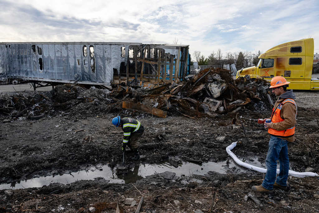 A cleanup crew detects and decontaminates water in a ditch during a tour of the UPS plane crash site, Tuesday, Jan. 13, 2026, in Louisville, Ky. (AP Photo/Jon Cherry)