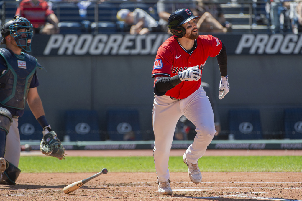 Cleveland Guardians' Daniel Schneemann watches his two-run home run off Seattle Mariners starting pitcher Bryce Miller along with catcher Cal Raleigh during the third inning of a baseball game, Sunday, Aug. 31, 2025, in Cleveland. (AP Photo/Phil Long)