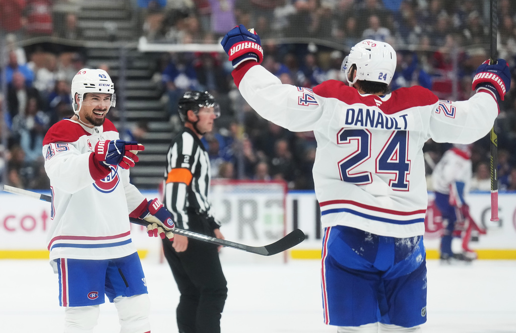 Montreal Canadiens' Alexandre Carrier (45) celebrates his goal against the Toronto Maple Leafs with Phillip Danault (24) during the third period of an NHL hockey game against the Montreal Canadiens in Toronto, Tuesday, Sept. 29, 2026. (Nathan Denette/The Canadian Press via AP)