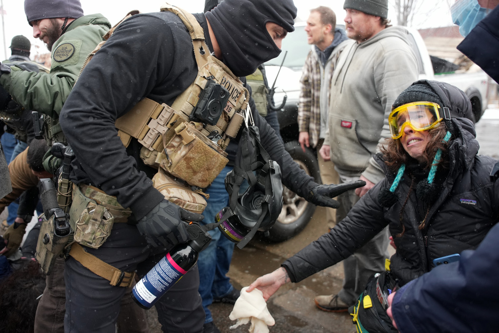 Federal agents detain a person on Wednesday, Jan. 21, 2026, in Minneapolis. (AP Photo/Angelina Katsanis)