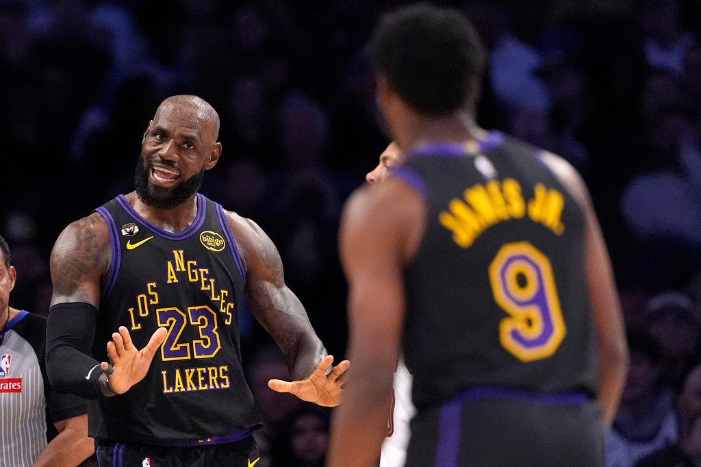 Los Angeles Lakers forward LeBron James, left, talks to guard Bronny James during the first half of an NBA basketball game against the Cleveland Cavaliers, Tuesday, March 31, 2026, in Los Angeles. (AP Photo/Mark J. Terrill)