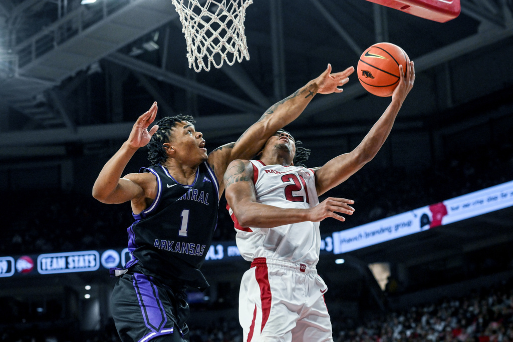 Arkansas guard D.J. Wagner (21) is fouled by Central Arkansas guard Camren Hunter (1) as he drives to the basket during an NCAA college basketball game Tuesday, Nov. 11, 2025, in Fayetteville, Ark. (AP Photo/Michael Woods)