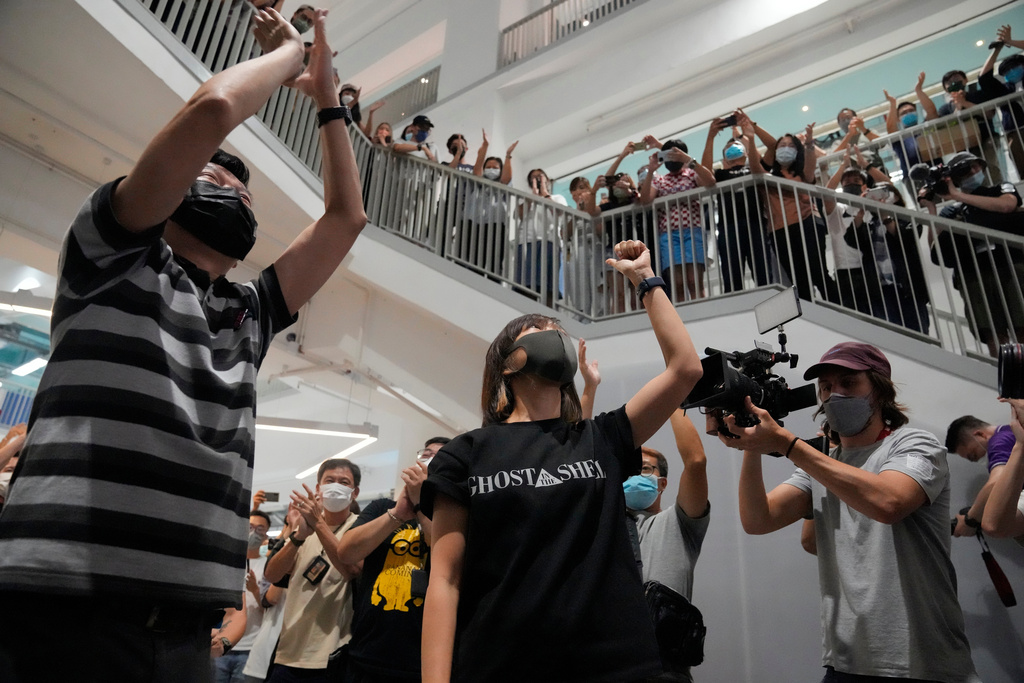 FILE - In this June 23, 2021, file photo, Lam Man-chung, left, executive editor-in-Chief of Apple Daily and Chan Pui-man, center, associate publisher of Apple Daily gesture at the headquarters before the newspaper stop publishing in Hong Kong. (AP Photo/Kin Cheung, File)