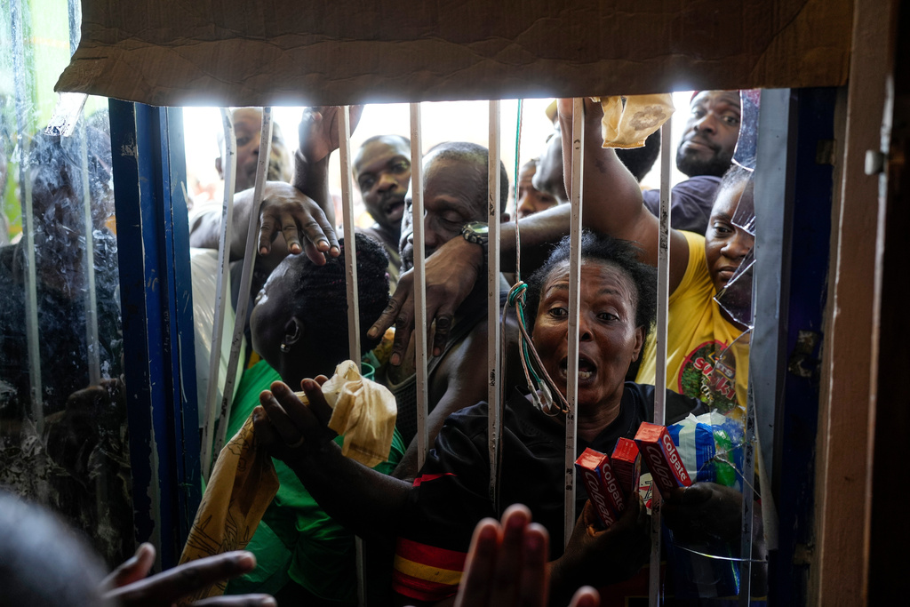 Residents crowd around a closed supermarket asking for supplies in Black River, Jamaica, Thursday, Oct. 30, 2025, in the aftermath of Hurricane Melissa. (AP Photo/Matias Delacroix)