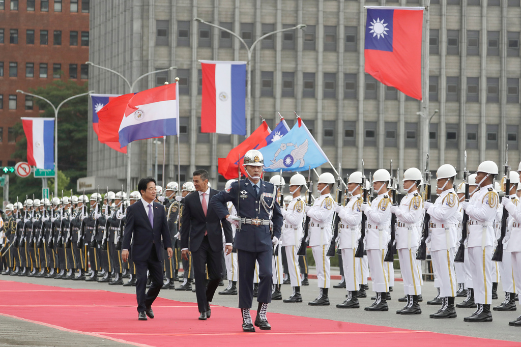 Paraguayan President Santiago Pena, center, accompanied by Taiwan President Lai Ching-te, left, reviews an honor guard at a military welcome ceremony in Taipei, Taiwan, Friday, May 8, 2026. (AP Photo/Chiang Ying-ying)