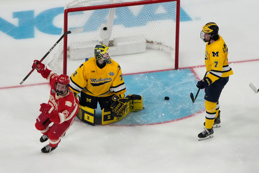 Denver forward Clarke Caswell (25) celebrates after Denver defenseman Cale Ashcroft scored against Michigan goaltender Jack Ivankovic (72) in the second period of a semifinal game of the NCAA Frozen Four men's college hockey tournament Thursday, April 9, 2026, in Las Vegas. (AP Photo/John Locher)