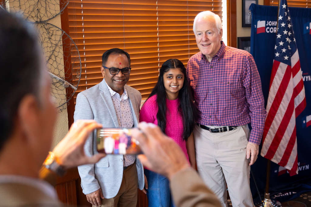 Kalpesh Patel and his 12-year-old daughter Keya pose for a photo with Sen. John Cornyn, R-Texas, during a campaign stop in The Woodlands, Texas, Saturday, Feb. 28, 2026. Keya recently completed a project on Cornyn for her seventh grade Texas history class. (AP Photo/Annie Mulligan)