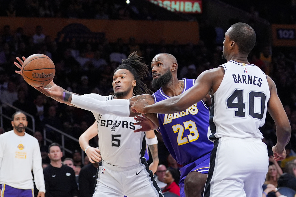 Los Angeles Lakers forward Lebron James (23) goes after a loose ball against San Antonio Spurs forward Harrison Barnes (40) and guard Stephon Castle (5) during the first half of an NBA Cup basketball game Wednesday, Dec. 10, 2025, in Los Angeles. (AP Photo/Jae C. Hong)