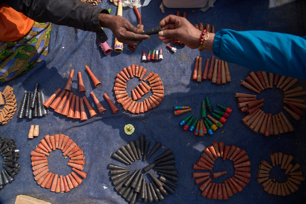A man displays smoking pot to sell to devotees during Maha Shivaratri festival at the Pashupatinath temple premises in Kathmandu, Nepal, Sunday, Feb. 15, 2026. (AP Photo/Niranjan Shrestha)
