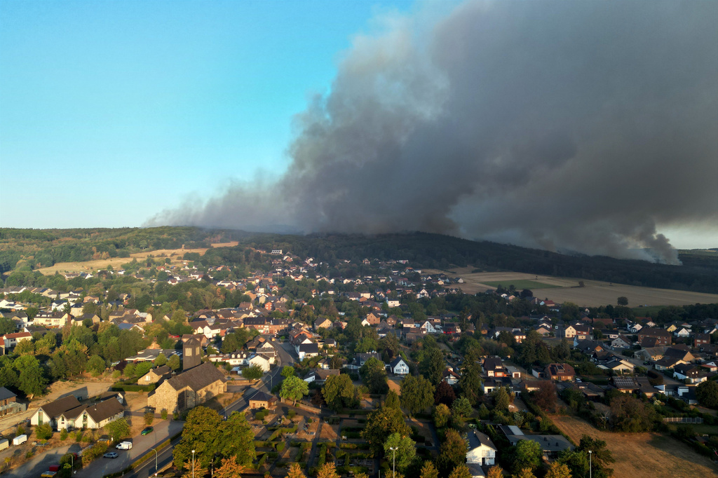 Thick smoke drifts over the Gey district from a forest fire in Hürtgenwald, Germany, Friday, Aug. 14, 2026. (Federico Gambarini/dpa via AP)