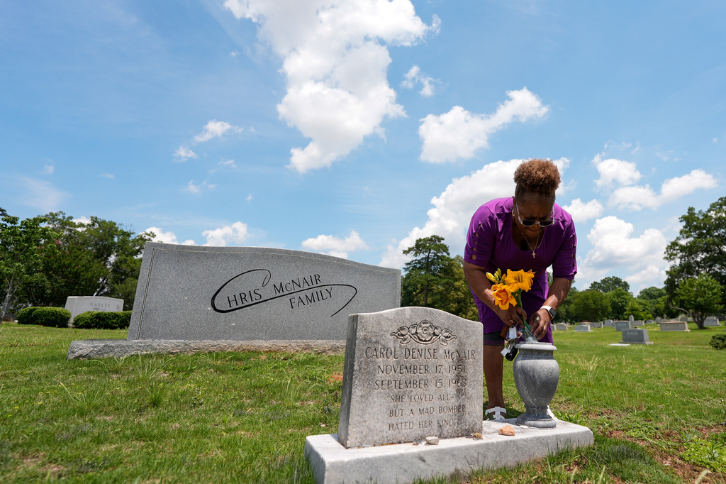 Lisa McNair arranges flowers on the grave of her late sister, Carol Denise McNair, Monday, June 1, 2026, in Birmingham, Ala. (AP Photo/Mike Stewart)