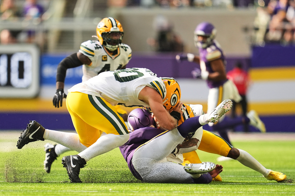 Minnesota Vikings quarterback Kyler Murray, center, is tackled by Green Bay Packers' Lukas van Ness, left, and Javon Bullard, right, during the first half of an NFL football game, Sunday, Sept. 13, 2026, in Minneapolis, Minn. (AP Photo/Abbie Parr)