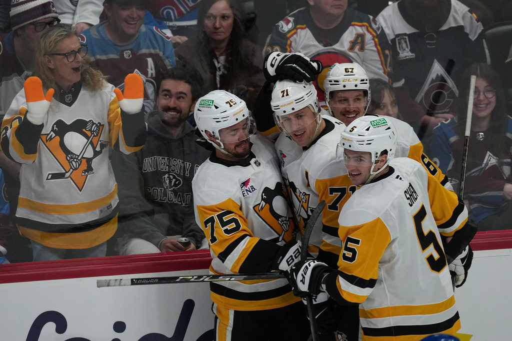 Pittsburgh Penguins center Evgeni Malkin, back center, is congratulated after scoring a goal by defenseman Connor Clifton, back left, right wing Rickard Rakell, back right, and defenseman Ryan Shea in the first period of an NHL hockey game against the Colorado Avalanche Monday, March 16, 2026, in Denver. (AP Photo/David Zalubowski)