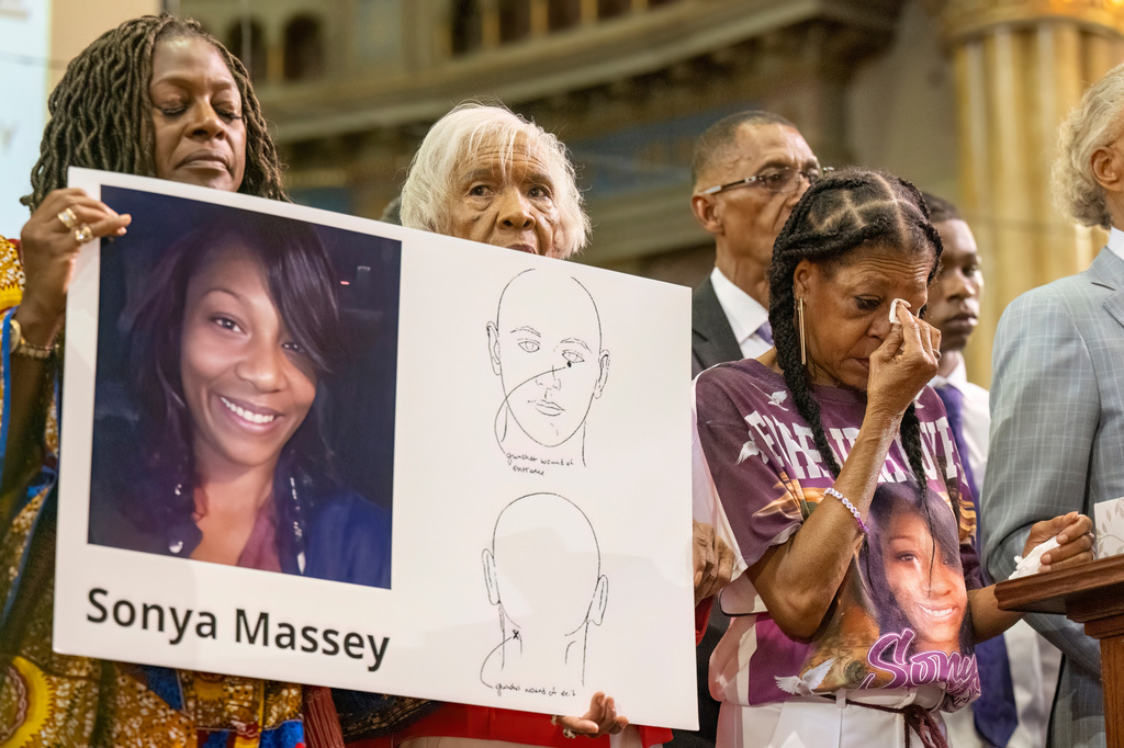 FILE - Donna Massey, center right, wipes tears from her face as she listens to Rev. Al Sharpton, right, speak during a news conference Tuesday, July 30, 2024, in Chicago, over the shooting death of her daughter Sonya, who was allegedly killed by Illinois sheriff's deputy Sean Grayson. (Tyler Pasciak LaRiviere/Chicago Sun-Times via AP, File