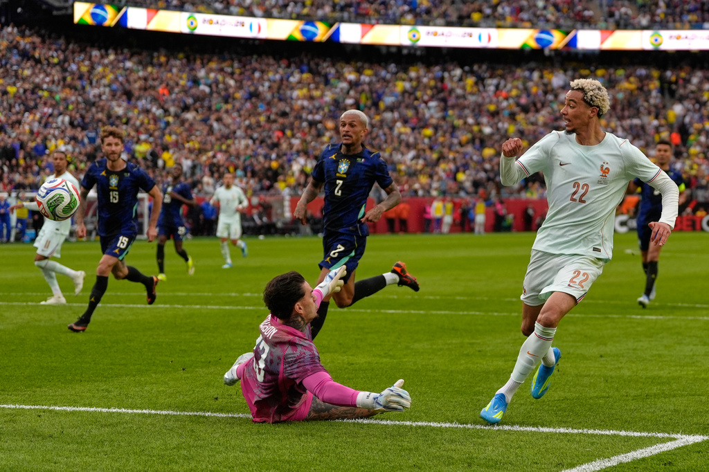 Hugo Ekitike of France scores his side's second goal past Brazilian goalkeeper Ederson during the international friendly soccer match between Brazil and France in Foxborough, Mass, Thursday, March 26, 2026. (AP Photo/Charles Krupa)